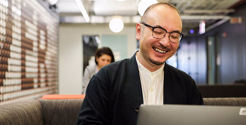 Colleague Smiling And Working On Laptop